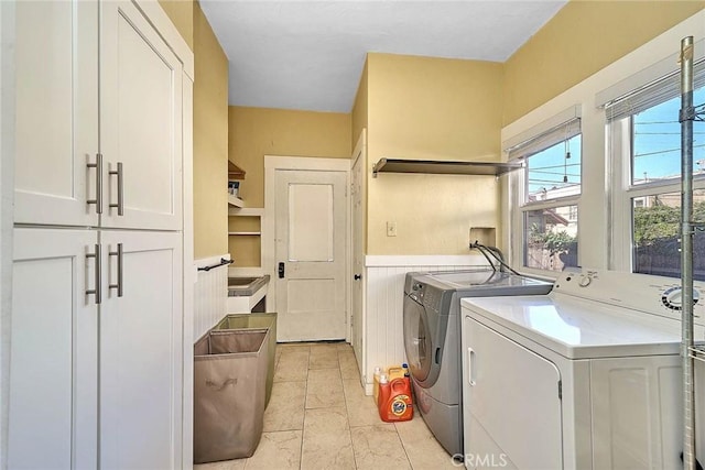 laundry area with cabinets and washing machine and clothes dryer