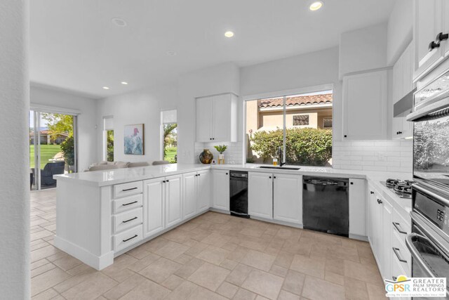 kitchen with kitchen peninsula, appliances with stainless steel finishes, white cabinets, and decorative backsplash