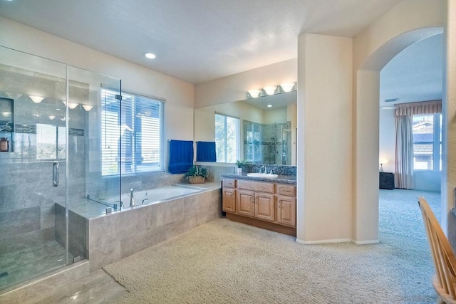 bathroom with vanity, plenty of natural light, and plus walk in shower