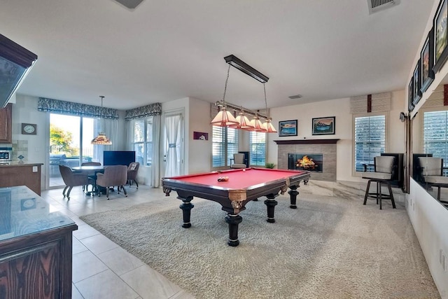 game room with light tile patterned flooring, pool table, a tile fireplace, and a wealth of natural light