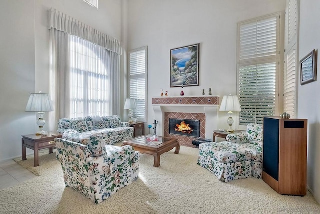 living room with a high ceiling, light tile patterned flooring, and a fireplace