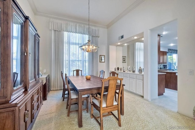 carpeted dining room with crown molding and a notable chandelier