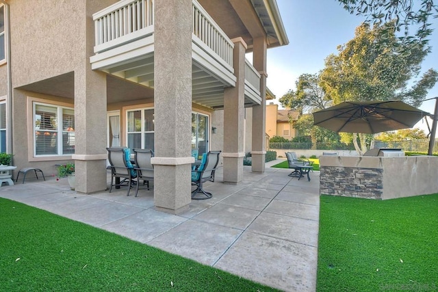 view of patio featuring a balcony and exterior kitchen