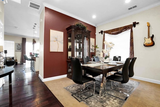 dining area featuring a wealth of natural light, crown molding, and hardwood / wood-style flooring