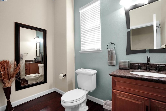 bathroom with toilet, vanity, and hardwood / wood-style flooring