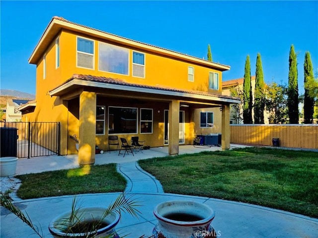 rear view of house featuring a mountain view, a patio, cooling unit, and a lawn