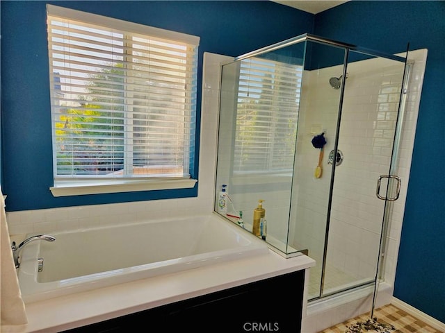 bathroom with tile patterned floors, independent shower and bath, and a wealth of natural light