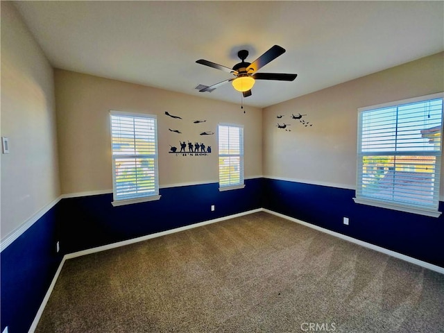 carpeted spare room featuring ceiling fan and a healthy amount of sunlight