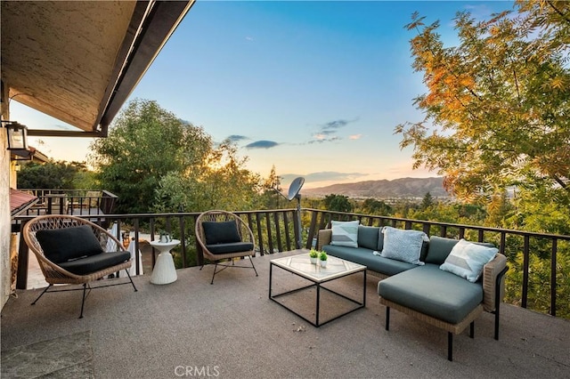 patio terrace at dusk with a balcony and an outdoor hangout area