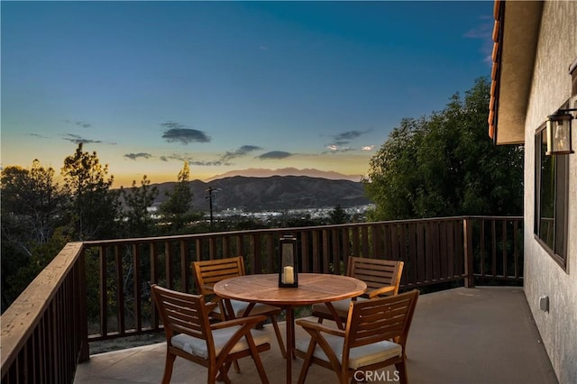 balcony at dusk featuring a mountain view