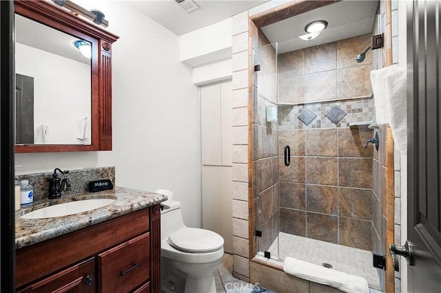 bathroom featuring tile patterned floors, vanity, toilet, and an enclosed shower