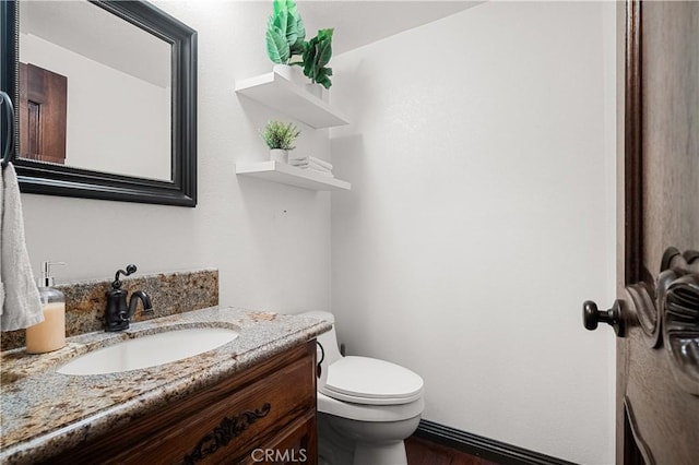 bathroom featuring wood-type flooring, vanity, and toilet