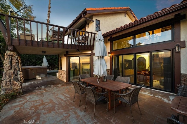 view of patio / terrace featuring a balcony and a hot tub