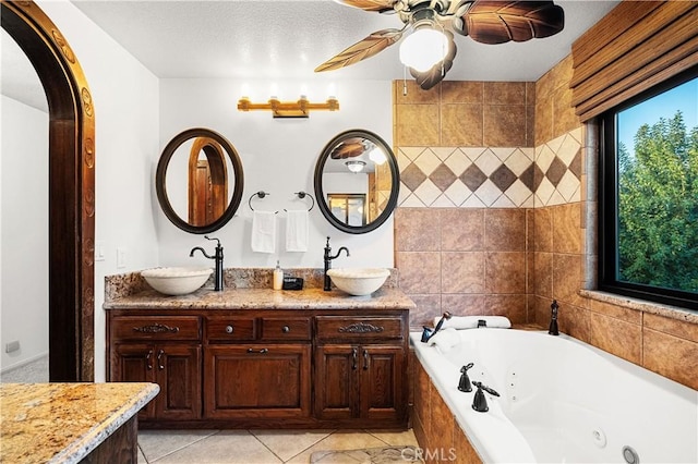 bathroom with vanity, tile patterned floors, ceiling fan, and tiled tub