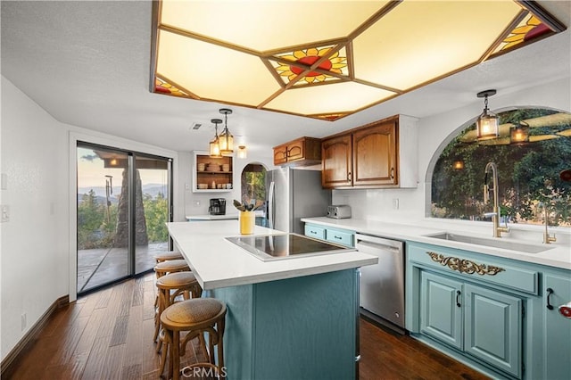 kitchen featuring appliances with stainless steel finishes, sink, a center island, dark hardwood / wood-style floors, and a breakfast bar area