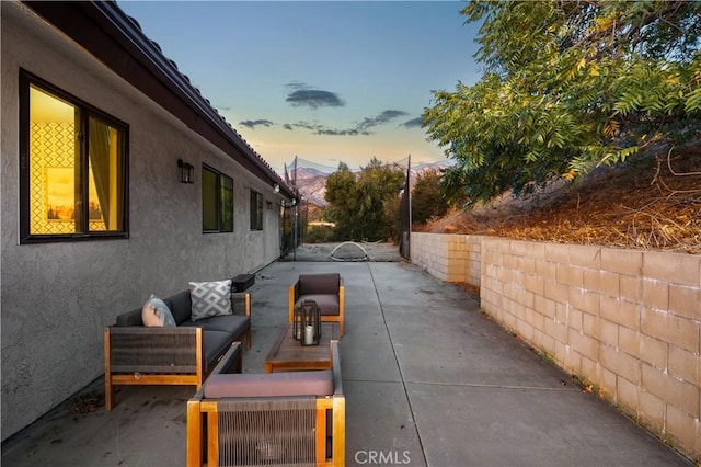 patio terrace at dusk featuring an outdoor hangout area