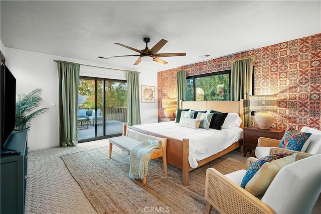 carpeted bedroom featuring multiple windows, ceiling fan, and access to exterior