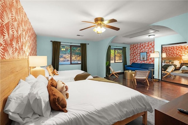 bedroom featuring multiple windows, ceiling fan, and dark wood-type flooring