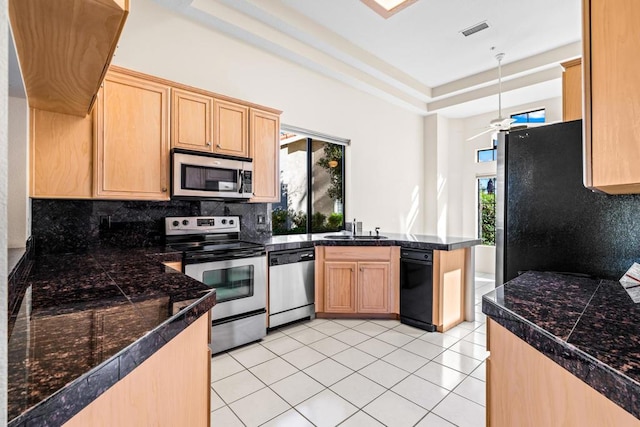 kitchen with ceiling fan, sink, tasteful backsplash, light tile patterned floors, and appliances with stainless steel finishes