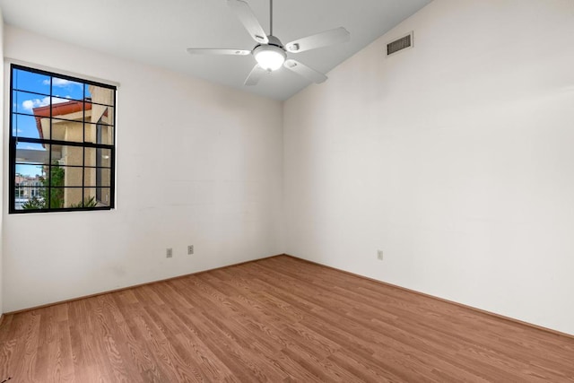 spare room with vaulted ceiling, light hardwood / wood-style flooring, ceiling fan, and a healthy amount of sunlight