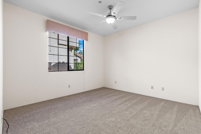 carpeted spare room with ceiling fan