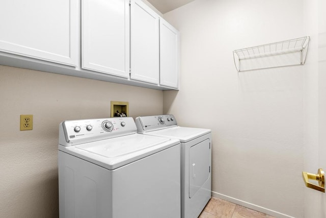 clothes washing area featuring separate washer and dryer and cabinets