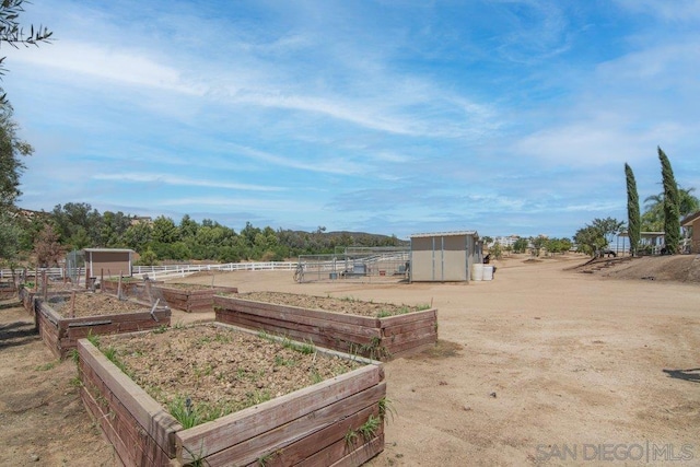 view of yard with a rural view and a storage shed