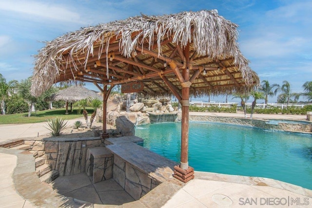 view of swimming pool with a gazebo and pool water feature