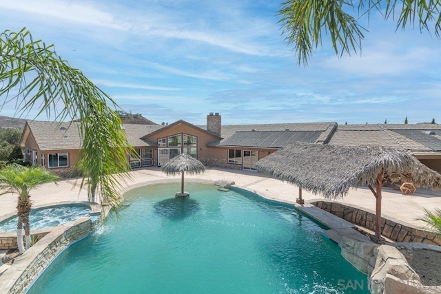 view of swimming pool featuring an in ground hot tub and a patio