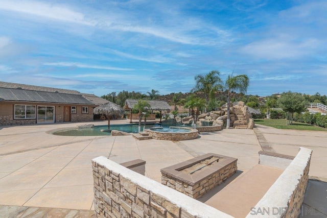 view of swimming pool with a patio and an outdoor fire pit