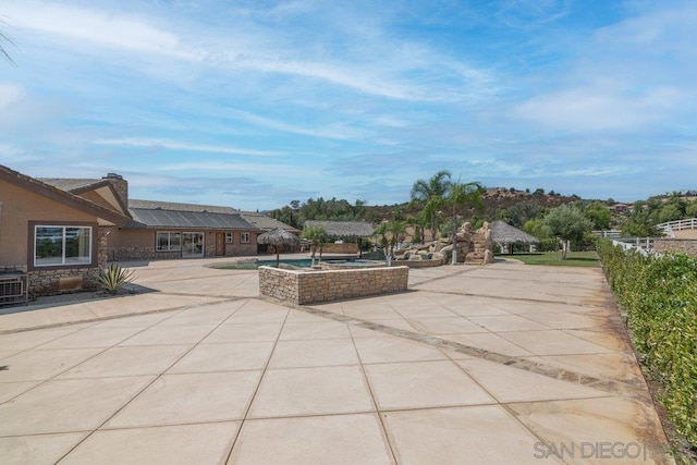 view of patio featuring an in ground hot tub