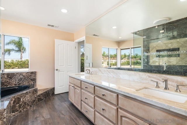 bathroom featuring wood-type flooring, vanity, separate shower and tub, and a healthy amount of sunlight