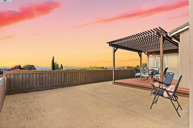 patio terrace at dusk featuring a pergola