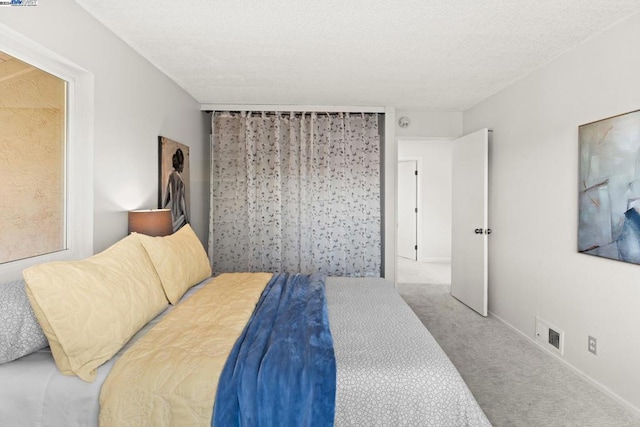 carpeted bedroom featuring a textured ceiling