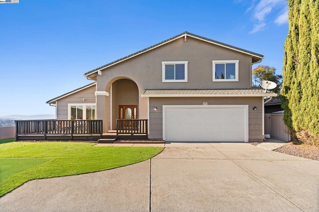 view of front of home with a garage, a front lawn, and a deck