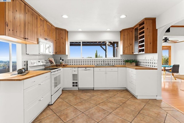 kitchen with ceiling fan, sink, white appliances, decorative backsplash, and white cabinets