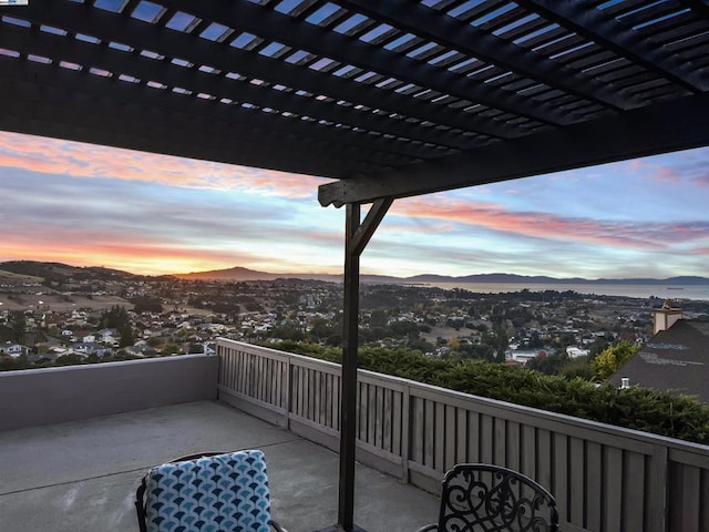 balcony at dusk featuring a pergola and a mountain view