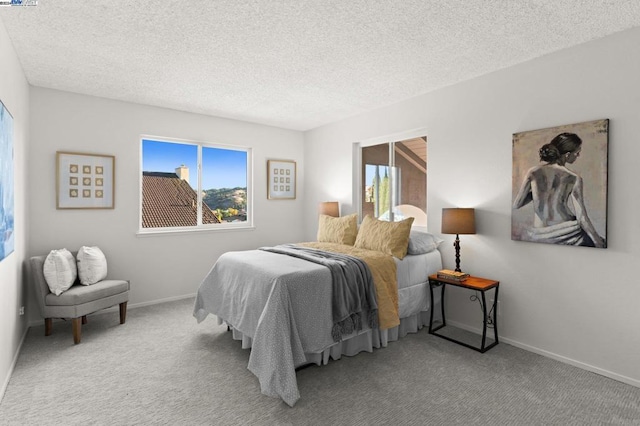 carpeted bedroom featuring a textured ceiling and multiple windows