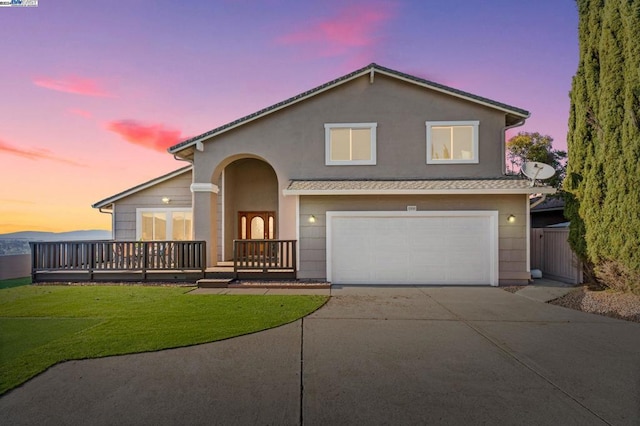 view of front of property with a wooden deck, a yard, and a garage