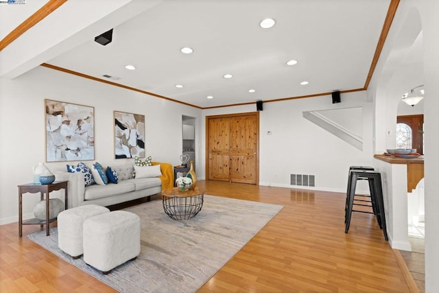 living room with wood-type flooring and ornamental molding