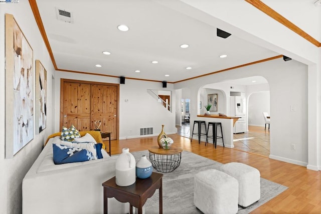 living room featuring light wood-type flooring and ornamental molding