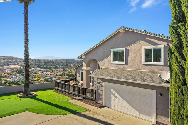 view of front facade featuring a mountain view, a front yard, and a garage