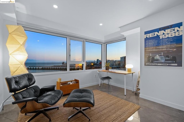 living area featuring a water view and concrete flooring