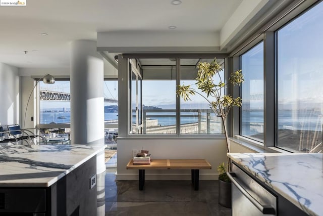 kitchen with a water view and light stone counters