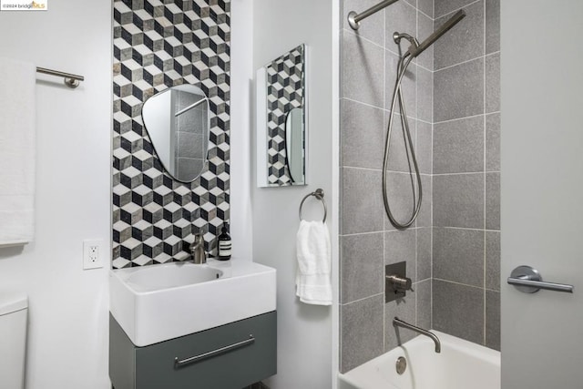 full bathroom featuring tiled shower / bath combo, toilet, and vanity