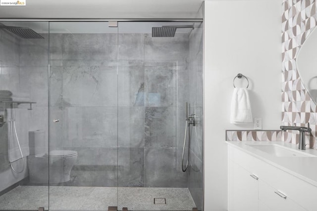 bathroom with vanity, a shower with shower door, and toilet