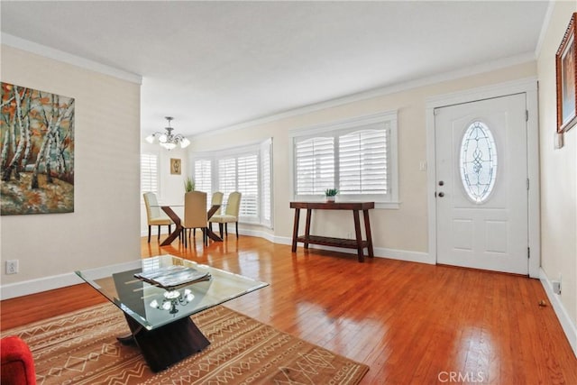 foyer entrance featuring a chandelier, crown molding, and wood-type flooring