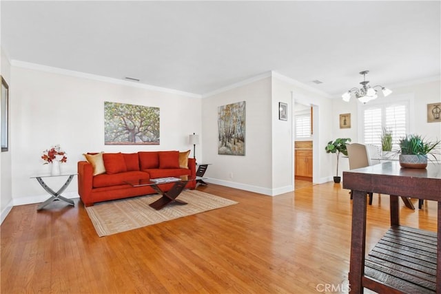 living room with a chandelier, light hardwood / wood-style flooring, and crown molding