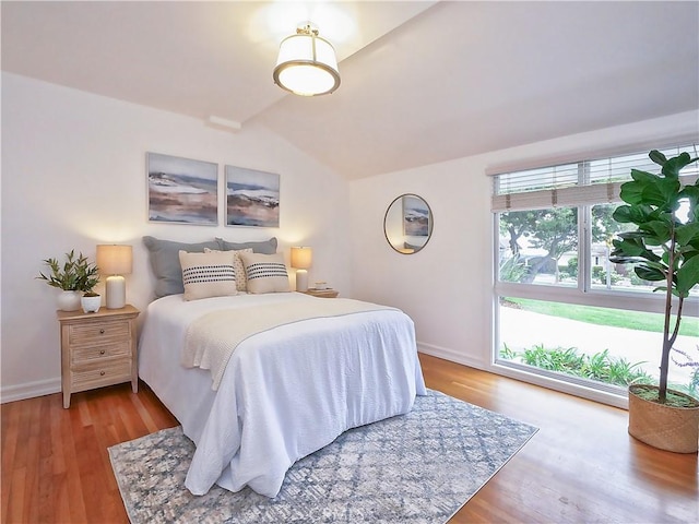 bedroom with wood-type flooring and lofted ceiling