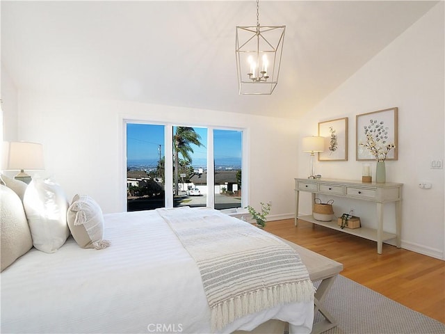 bedroom with access to outside, a chandelier, vaulted ceiling, and hardwood / wood-style flooring